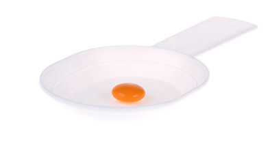 Orange pill on a white plastic spoon
