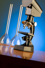 Microscope against blue gradient background