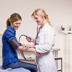 Doctor checking woman blood pressure