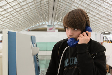 adolescent téléphonant depuis l'aéroport