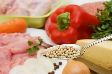 Spices on a spoon against vegetables