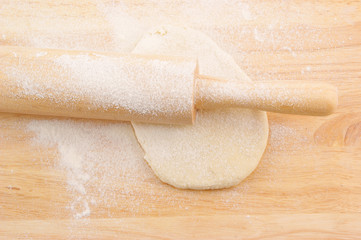 Pastry and rolling pin on wooden background