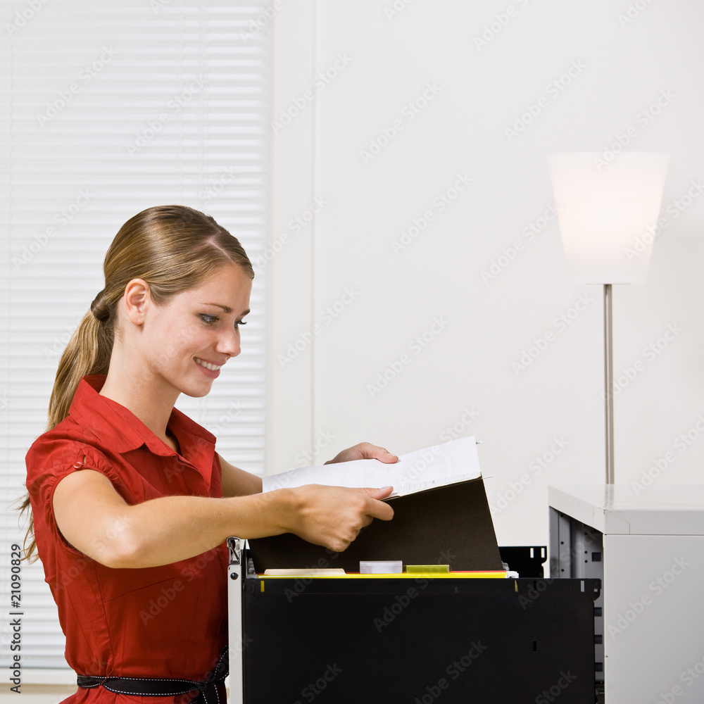 Wall mural businesswoman putting file in file cabinet