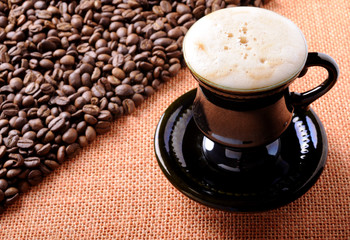 Background of the coffee beans and sackcloth with cup