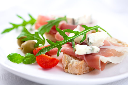 Canapes with prosciutto crudo and gorgonzola cheese