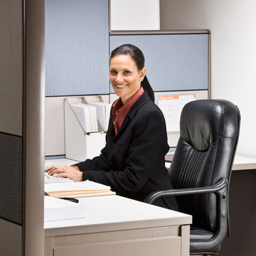 Businesswoman sitting at desk smiling