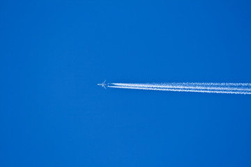 blue sky with condensation trail of aircraft