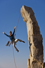Female rock climber rappelling.