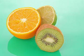 Orange and other fruits on green