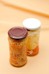 Glass jars with marinated vegetables  isolated on the white back