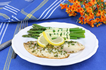 Healthy, fresh tilapia fillets with asparagus and Hollandaise sa