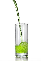 green juice pouring into glass isolated on white