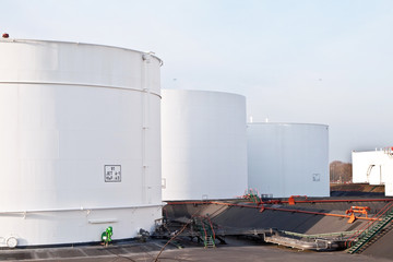white tanks in tank farm with blue sky