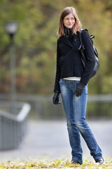 Portrait of a pretty young woman standing in a park on a lovely