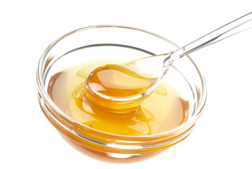 Glasschale mit Honig und Löffel