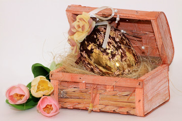 Złote jajo w kuferku i tulipany