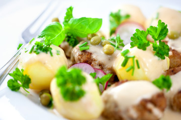 Frikadeller and potatoes with white sauce and herbs