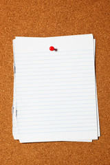Writing paper pinned on corkboard