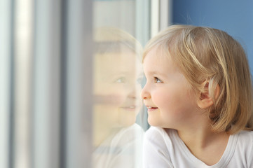 girl sits at  window