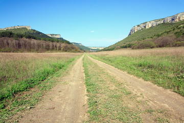 Fototapeta na wymiar Spring Crimean mountain landscape with road in valley (Mangup Ka