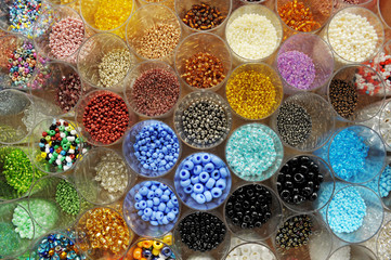 many transparent jars full of colored beads