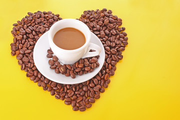 Small white cup of coffee with coffee grain on yellow background