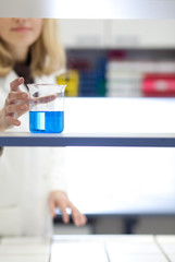 female researcher carrying out research/experiments in a chemist