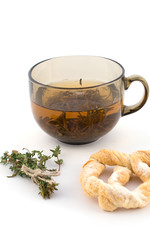 Fototapeta premium Cup of green tea with a bundle of herbs and bagel