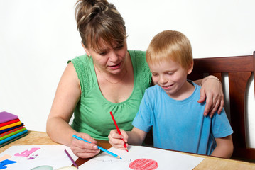 Mother and son are drawing the picture together