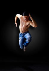 modern dancer poses in front of the old dirty wall.