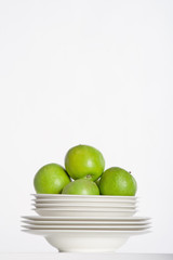 white plates and green apples
