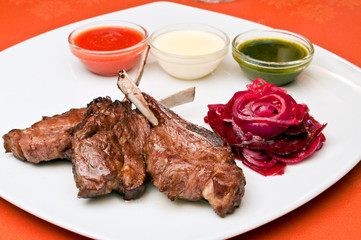 Closeup of a grilled lamb ribs with beet-root carpaccio and Thre