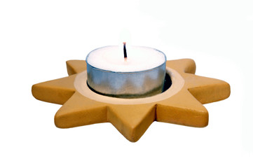 Teelicht in einem Weihnachts-Stern vor weißem Hintergrund.