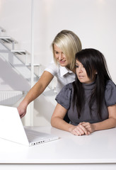 Two friendly business women working in office