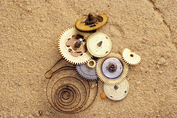 parts of clockwork mechanism on the sand