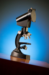 Microscope against blue gradient background