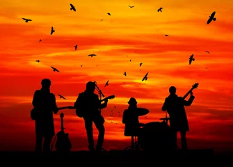 Crédence de cuisine en verre imprimé Groupe de musique silhouettes de musiciens contre le coucher du soleil