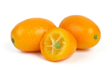 Two whole and sliced kumquat fruits