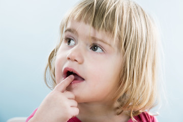 kleines Mädchen mit Finger an den Lippen