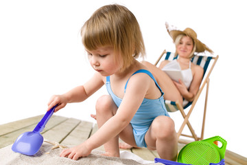 Beach - Mother with child playing with toys in sand
