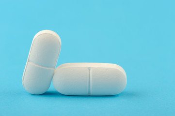 Two white tablet on a blue background.