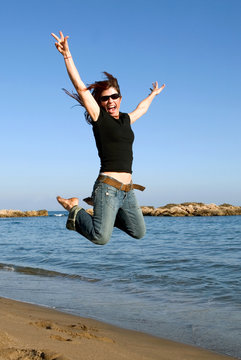 Woman leaping into the air on a beach