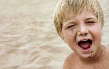 Boy covered in sand