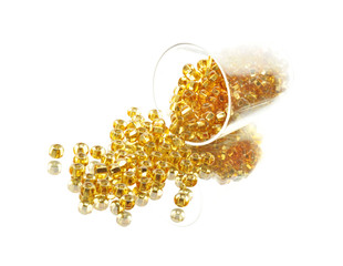 golden glass beads in small glass. Isolated comosition.