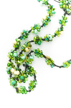 isolated string of transparent green and yellow glass beads