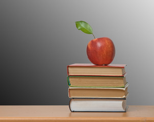 Red apple and books on desk
