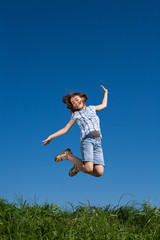 Girl jumping, running against blue sky