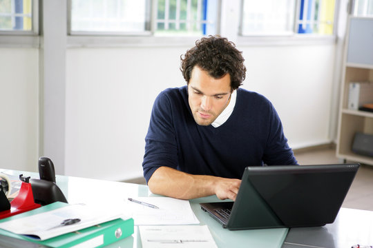 Portrait d'un jeune homme au bureau devant ordinateur portable