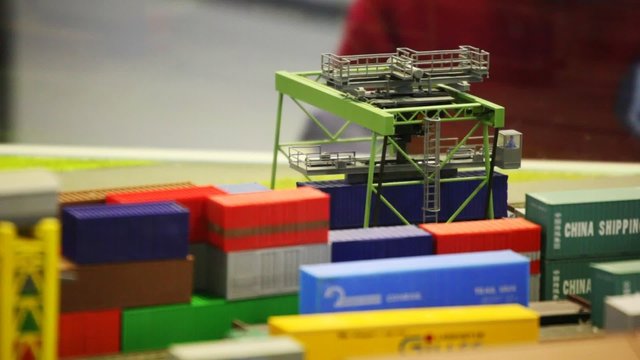 moving toy mobile cargo loader on railway among containers