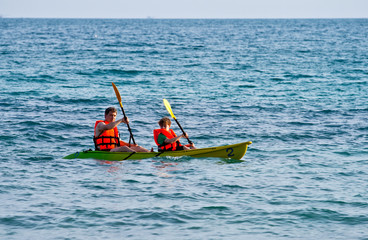 Obraz premium father and son are padelling with a canoe on open sea